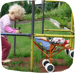 Kind spielt mit Puppenwagen